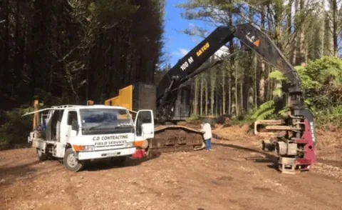 C.D Contracting Field Services truck with its doors open on a forestry track, next to a tracked machine fitted with a Satco log processing head
